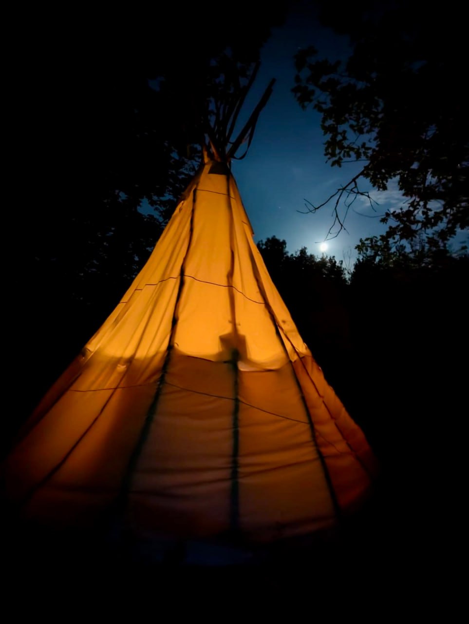 Le tipi illuminé de nuit sous la pleine lune